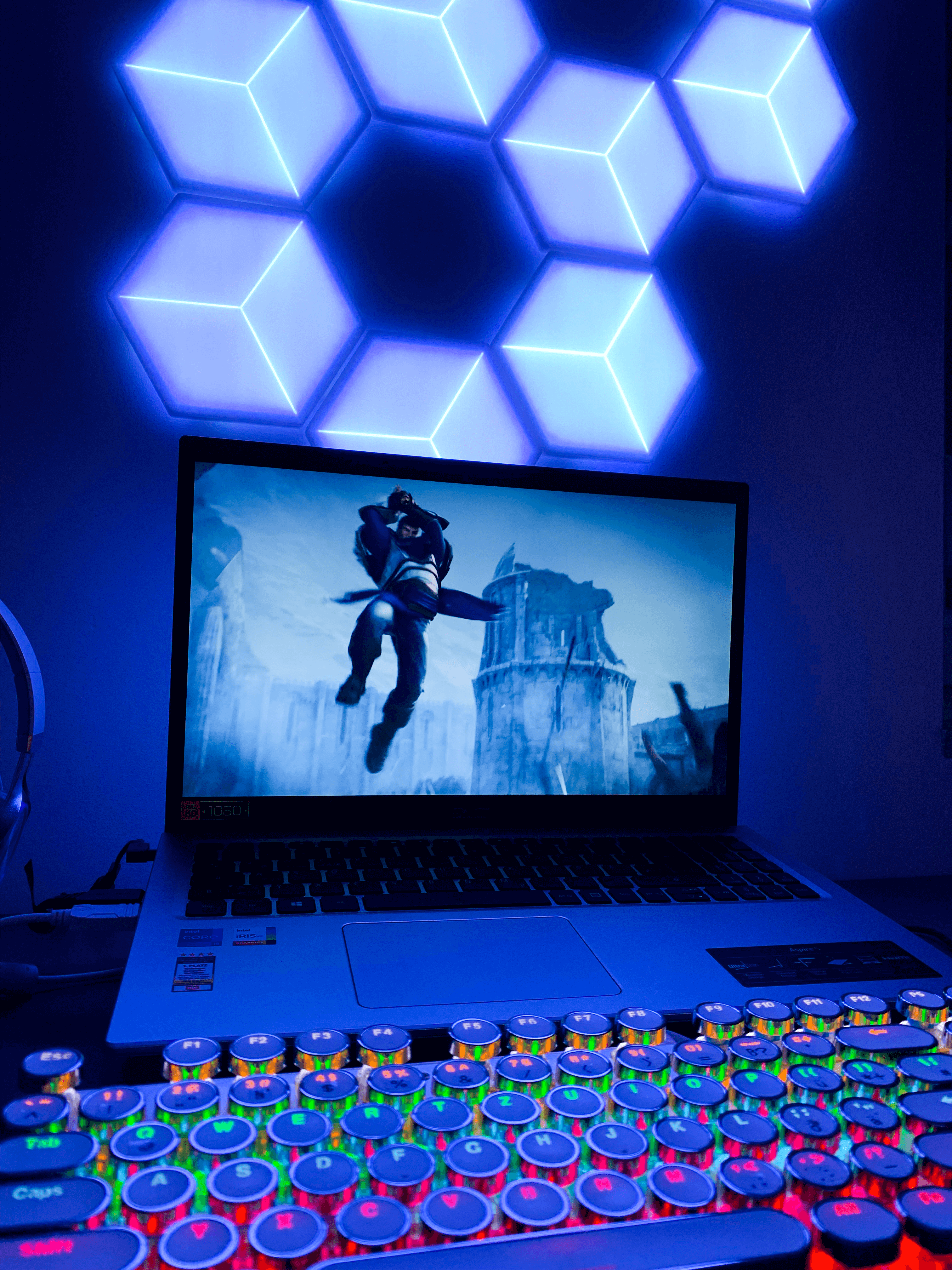 Govee 3D-Panels, die tatsächlich dreidimensional wirken, leuchten passend zu einem Gaming-Laptop und dem darauf zu sehenden Bild eines Kriegers in Blau.