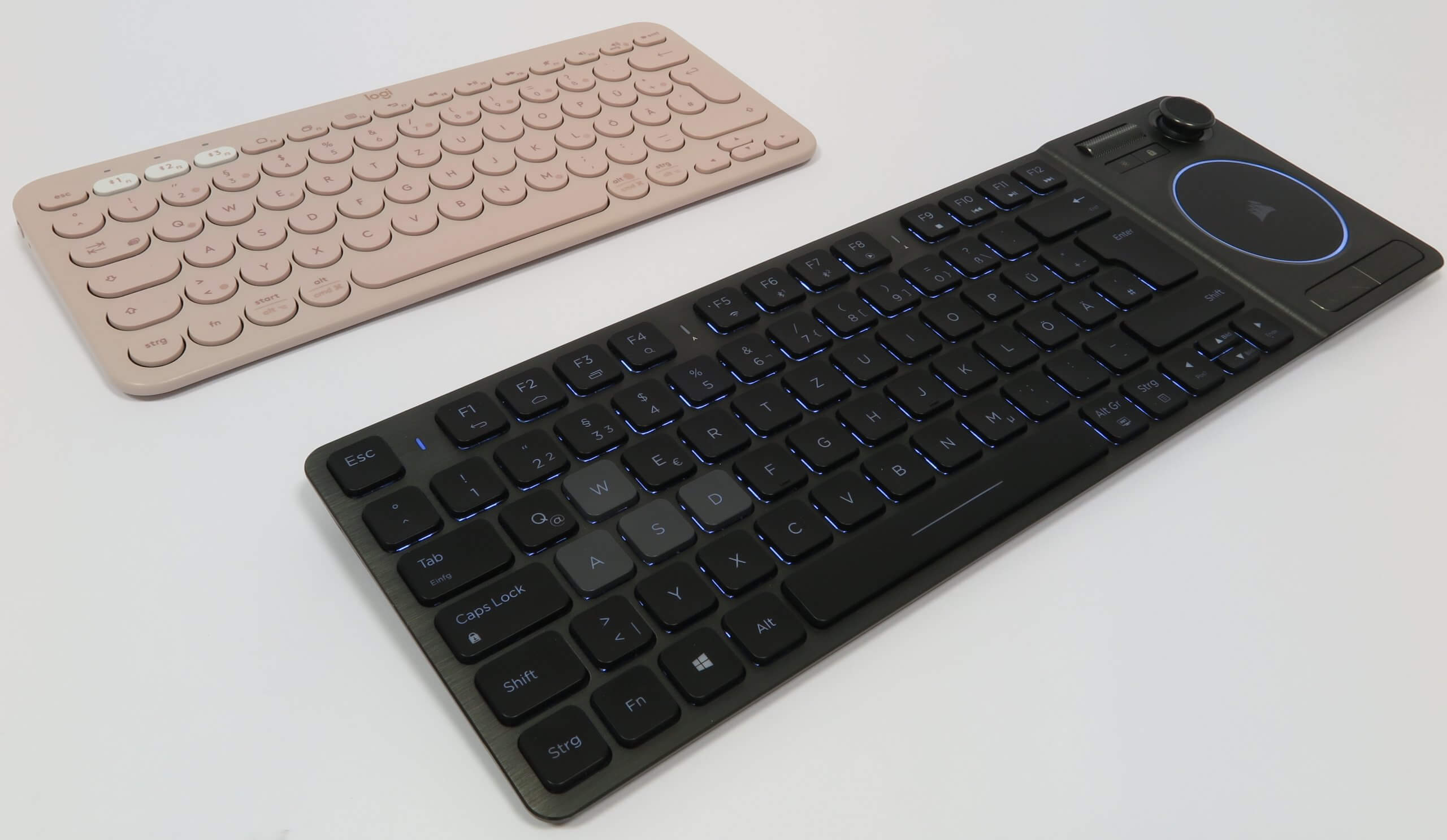 Zwei sehr flache Bluetooth-Tastaturen, eines ins Rosa, eines in Schwarz, mit unterschiedlichen Größen im Vergleich.