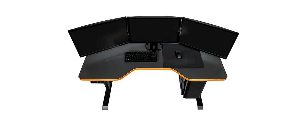 Ein höhenverstellbarer Gaming-Schreibtisch von Leetdesk vor weißem Hintergrund. Der Tisch ist schwarz mit orangen Zier-Elementen. Auf dem Leetdesk stehen 3 Monitore, außerdem sind eine Tastatur, eine Maus und ein Mauspad (alles in Schwarz) zu sehen.