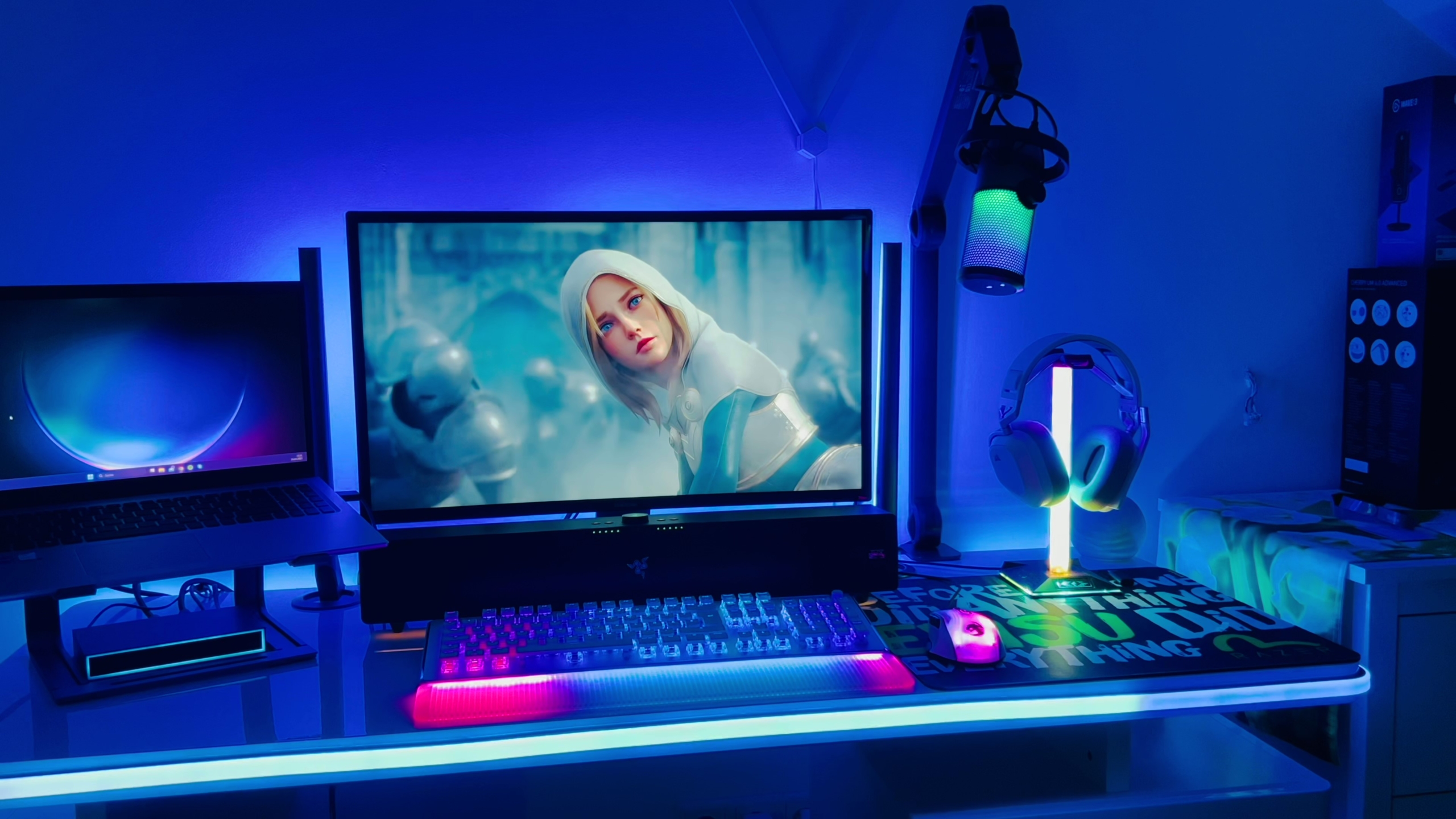 Ein Gaming-Schreibtisch in blaues LIcht gehüllt, das die Farben auf dem Bildschirm spiegelt. Das Licht wird erzeugt von den Govee Neon Rope Lights Desk sowie der Govee AI Gaming Sync Box.